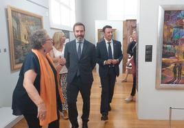 Jaio de la Puerta, comisaria de la exposición, ofrece una visita guiada al consejero de Turismo, Javier Hurtado, y al alcalde de Portugalete, Mikel Torres.