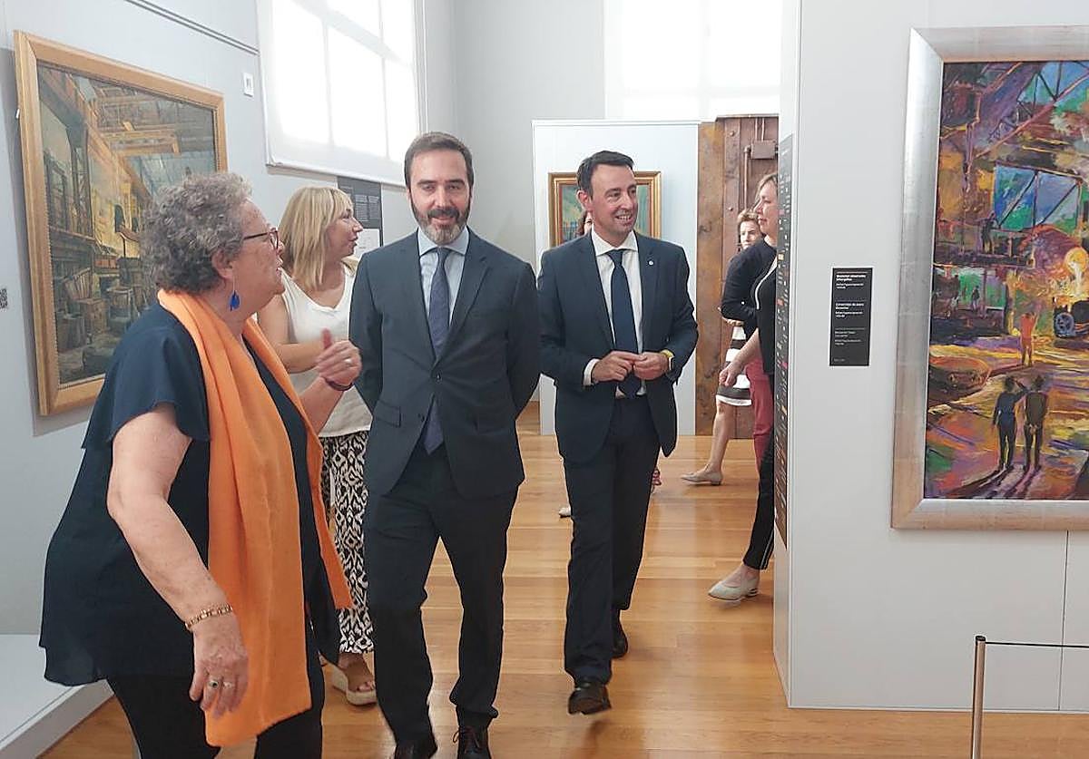 Jaio de la Puerta, comisaria de la exposición, ofrece una visita guiada al consejero de Turismo, Javier Hurtado, y al alcalde de Portugalete, Mikel Torres.