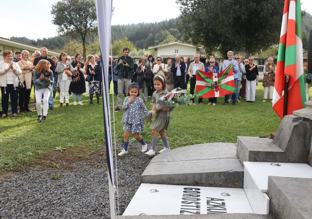 Dos niñas dejan unas flores en el panteón en el que descansa Ramón Azkue