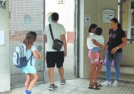Varios padres y alumnos, en la entrada de un centro escolar.