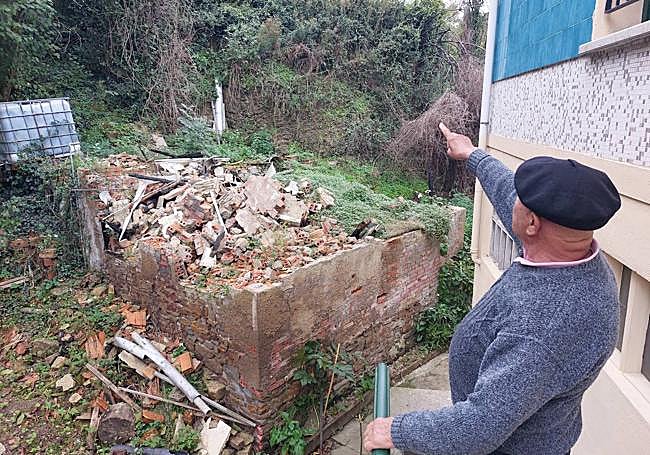 Pepe Martín señalando el lugar del que vinieron las llamas, que quemaron esa casa que se encuentra a apenas un metro de su vivienda.