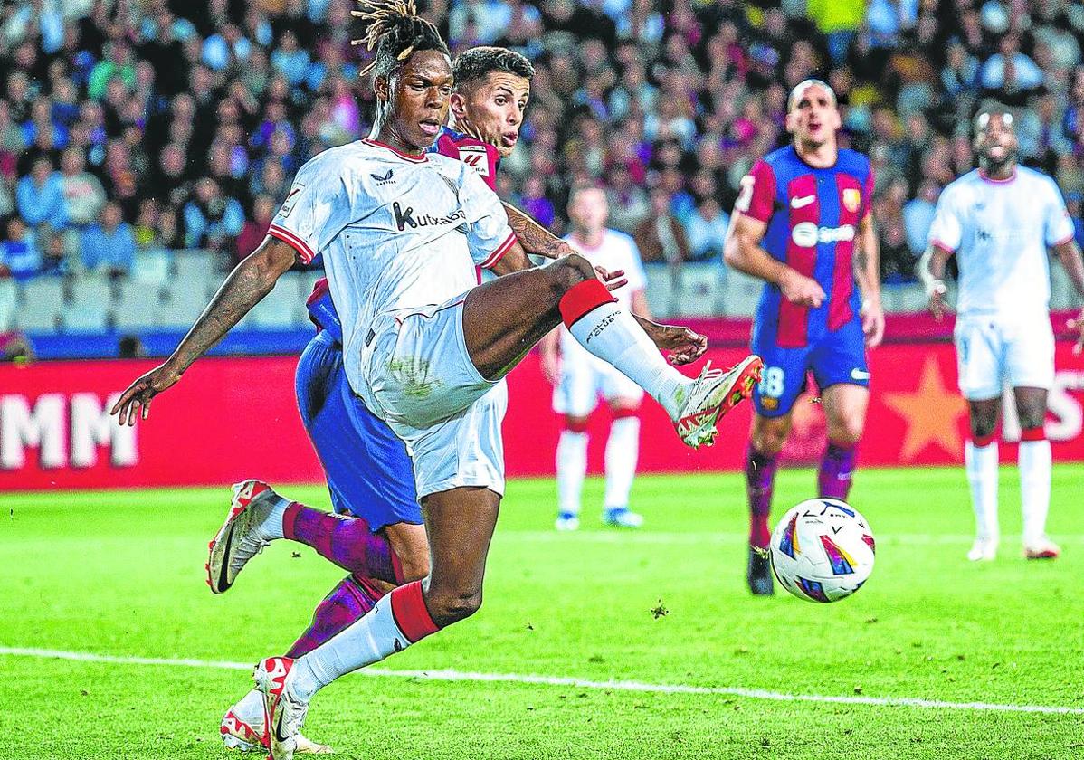 Nico Williams trata de proteger el balón ante la presión de Cancelo.