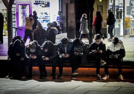 Un grupo de adolescentes mira sus teléfonos móviles en la plaza de la Virgen Blanca.