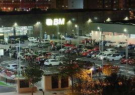 Varios grupos de personas beben y comen en el parking del nuevo centro comercial de Salburua.