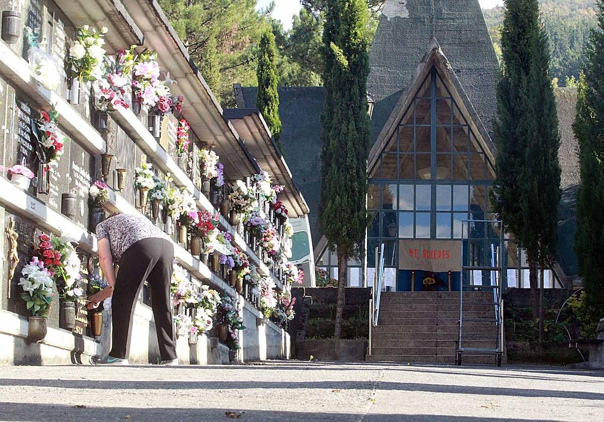 Una mujer prepara las flores en el cementerio de Basauri antes de la festividad de Todos los Santos.