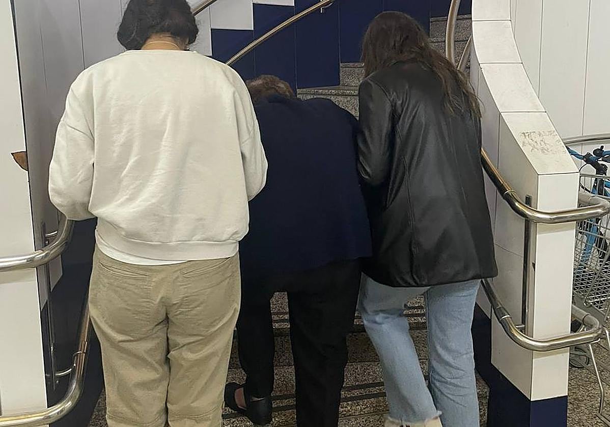 Una usuaria es acompañada por dos de sus familiares a subir las escaleras del centro