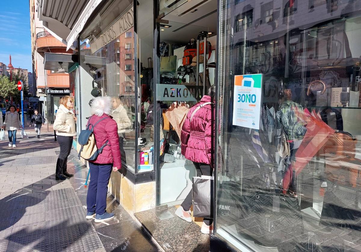 Imagen principal - Sobre estas líneas, varias vecinas de Barakaldo observando el género de Bolsos Azkona, uno de los comercios fabriles adheridos a la campaña; y dos comerciantes de Santurtzi, Lorena Navarro, de la juguetería Ametsak, y Pilar Escalante, de la tienda de moda Double Act.