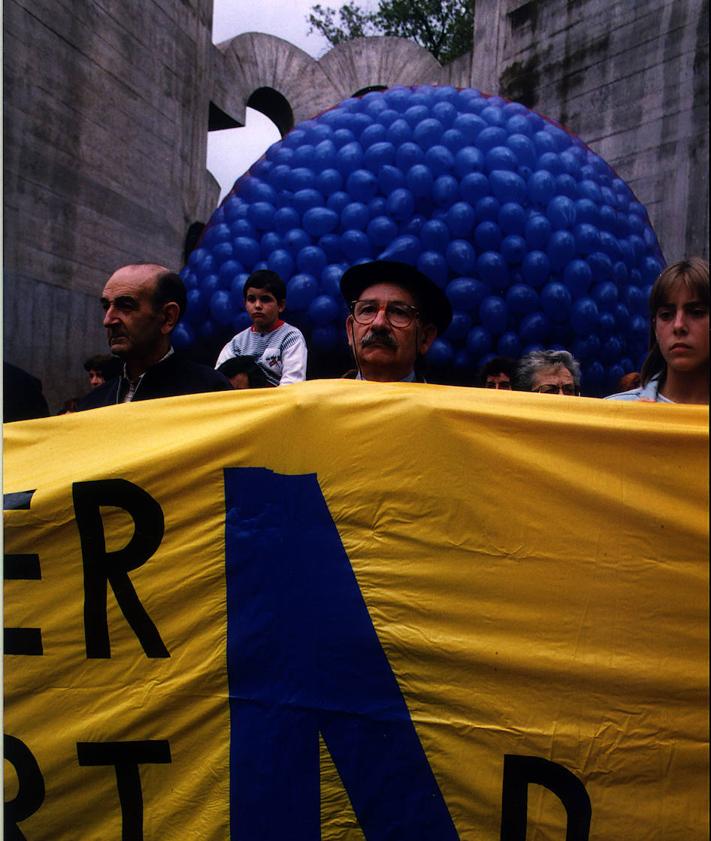 Imagen secundaria 2 - Arriba, pintadas contra al artista. Abajo, una manifestación en el Bosque de Oma en apoyo al pintor e Ibarrola, junto el lazo azul que creó.