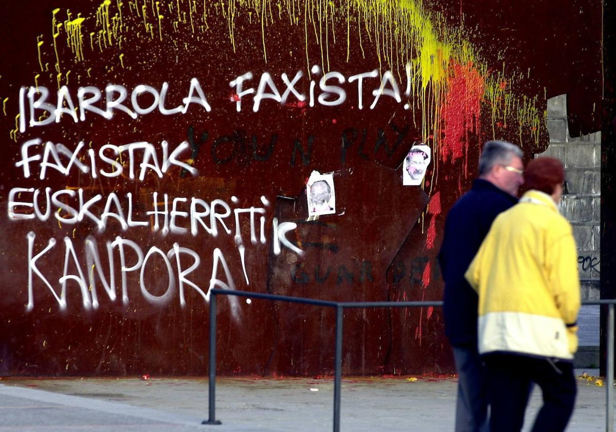 Imagen principal - Arriba, pintadas contra al artista. Abajo, una manifestación en el Bosque de Oma en apoyo al pintor e Ibarrola, junto el lazo azul que creó.