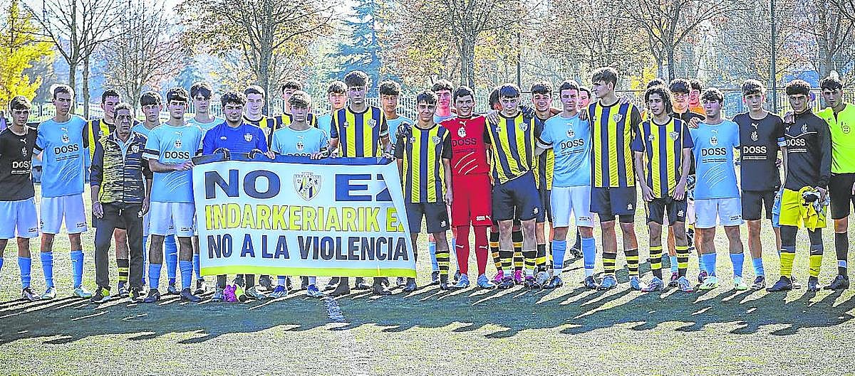 Los equipos del Lakua y Antiguoko, junto al árbitro, comparecieron con la pancarta en contra de la violencia poco antes de empezar el duelo.