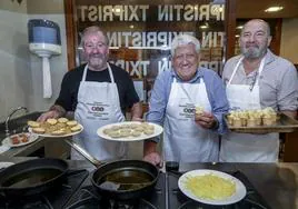 Kepa Baquedano, Roberto Ruiz de Mendarozketa, José Luis Delgado, en plena elaboración de la hamburguesa estilo Txipristin y el saco en el que guardaron el bacalao al pil-pil.