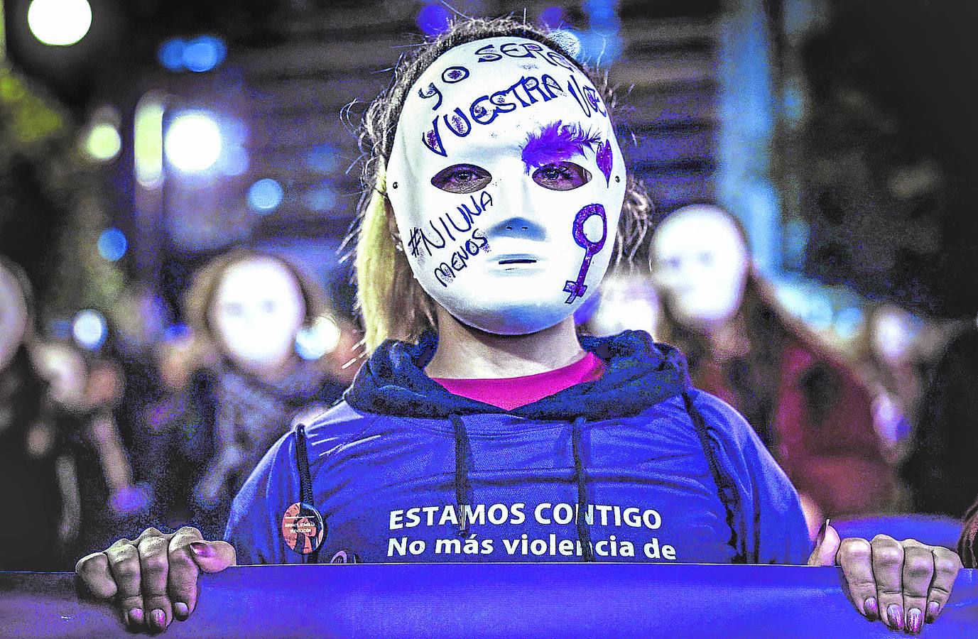 Una mujer enmascarada llora por las víctimas en el Día Internacional de la Eliminación de la Violencia Contra la Mujer.