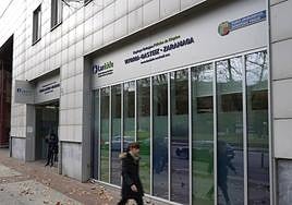 Una joven ajena a la noticia pasa frente a unaoficina de Lanbide en Vitoria.