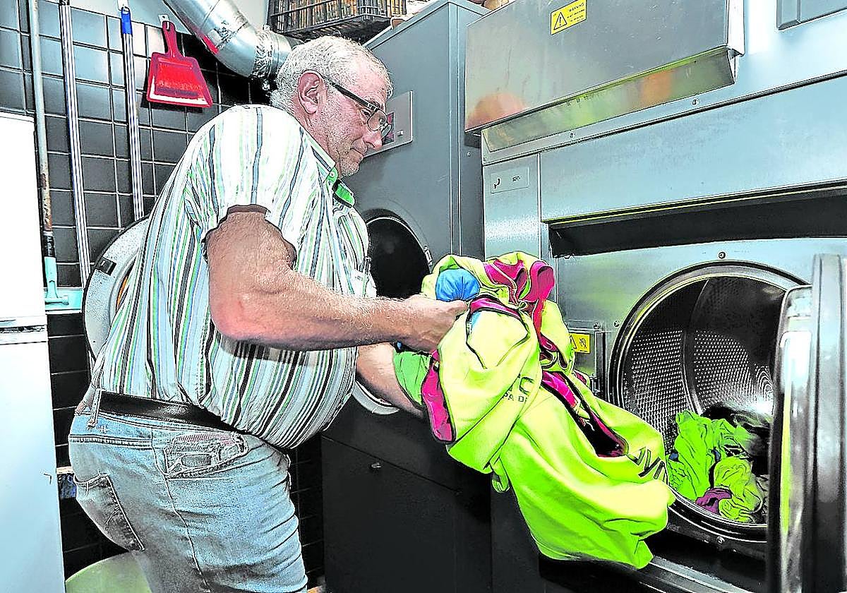 Dionisio Humara, presidente del Cayón, saca la ropa de los jugadores de la lavadora antes de ponerla a secar, una de sus muchas tareas.