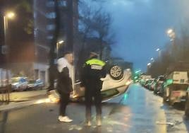 Un agente municipal con el conductor accidentado, ayer en la Avenida de los Huetos.