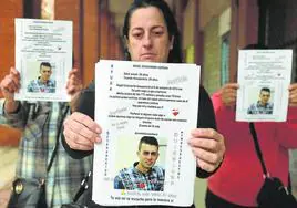 Maite muestra uno de los carteles con la foto y datos del desaparecido, que han vuelto a pegar en Portugalete y Bilbao.