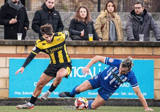 David Nates trata de superar a Jon Aranda en el partido entre la Cultural de Durango y el Portugalete.