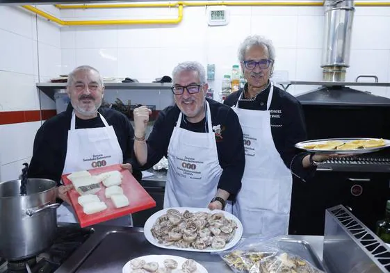 Arturo Fernández de Pinedo muestra el bacalao, mientras Pruden Cuenca sostiene las orejas de cerdo y Miguel Ángel González lleva a la mesa las zamburiñas en el concurso gastronómico.