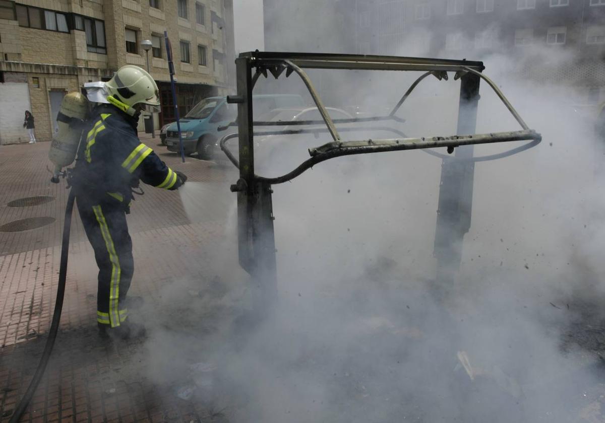 Bomberos sofocan un anterior incendio de un contenedor.