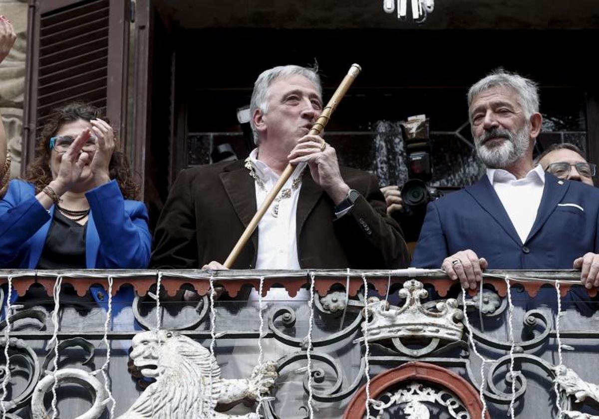 El nuevo alcalde de Pamplona, Joseba Asiron, de EH Bildu, besa la makila en el balcón del Ayuntamiento.