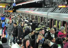 Pasajeros esperan al metro de Bilbao en plena en hora punta durante un día de alglomeraciones por una huelga.