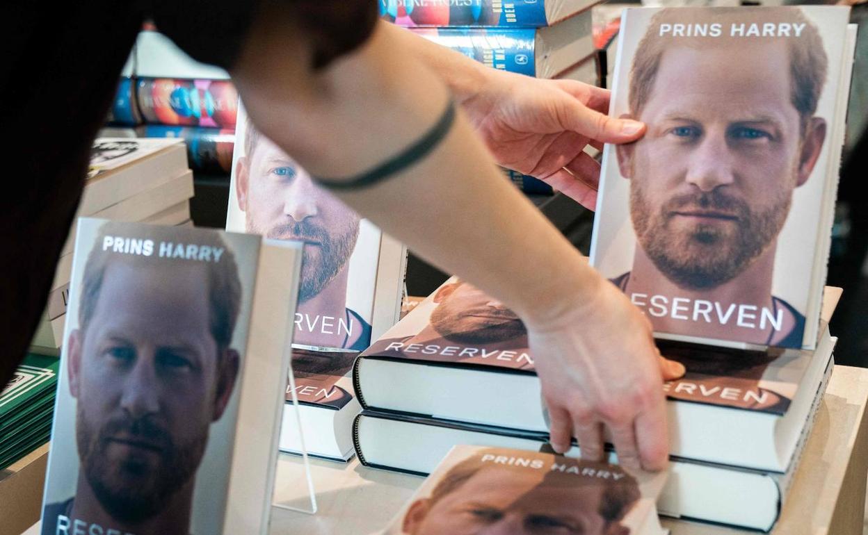 Una empleada de una librería coloca varios ejemplares de la autobiografía de Harry en un establecimiento de Copenhague.