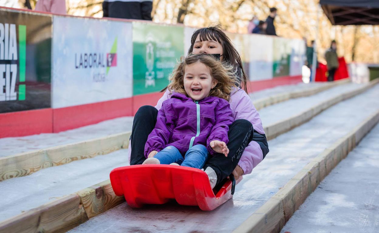 Dos niñas se tiran por el tobogán de hielo de La Florida. 