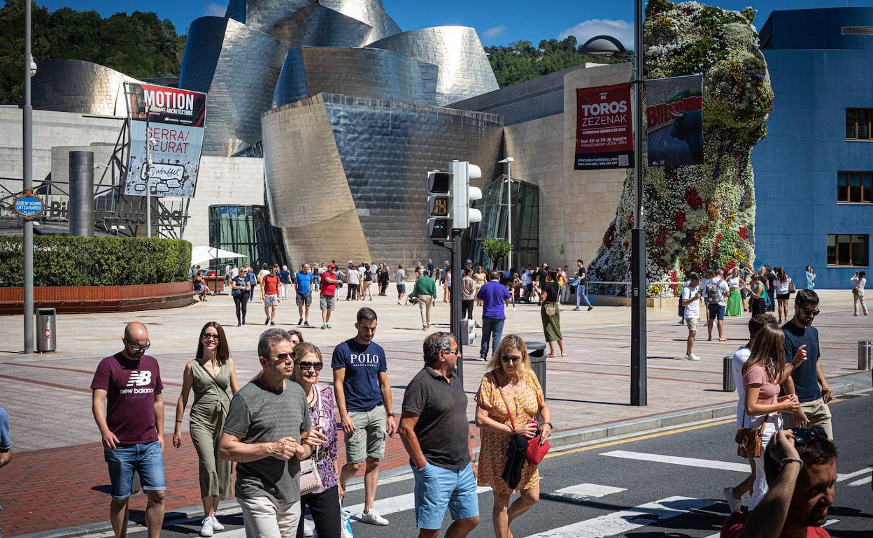 Un grupo de turistas pasea cerca del Guggenheim.