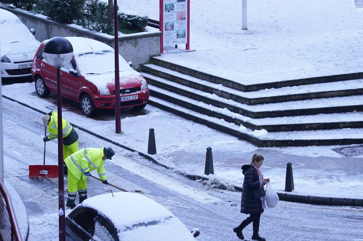 Operarios retiran la nieve acumulada en la calzada en Ermua.