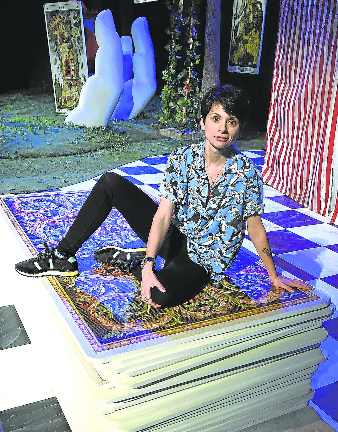 Marta Eguilior, sentada sobre un mazo de cartas gigantes que forma parte de la escenografía.