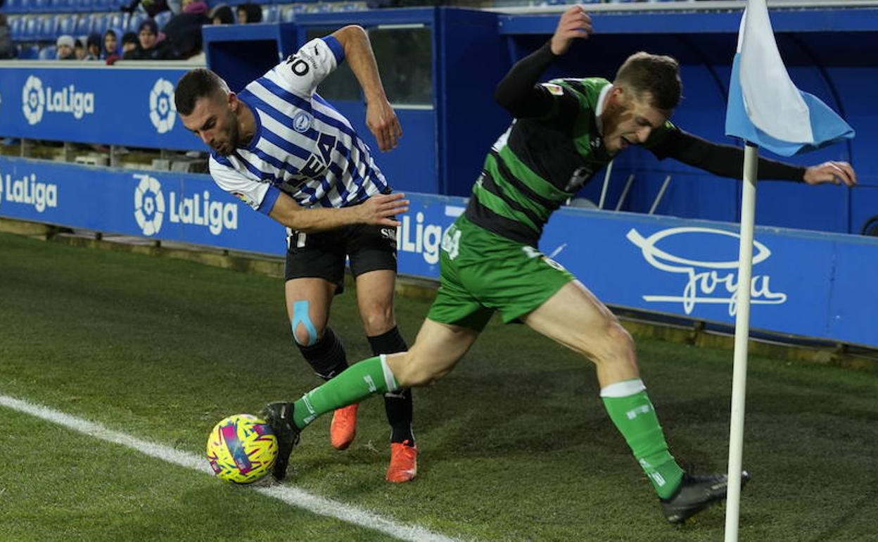 Luis Rioja regatea sobre la línea de banda y junto al córner a un defensor cántabro.