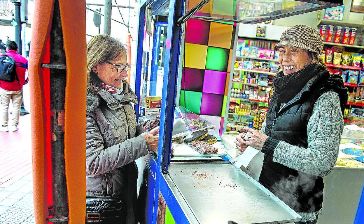 Ana María Anguita, a la derecha, entrega una bolsa de almendras a una clienta.