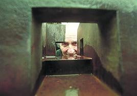 El escultor se asoma por una de sus obras.