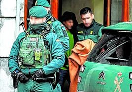 Agentes de la Guardia Civil con el detenido hoy en Romo, tras finalizar el registro de la vivienda.