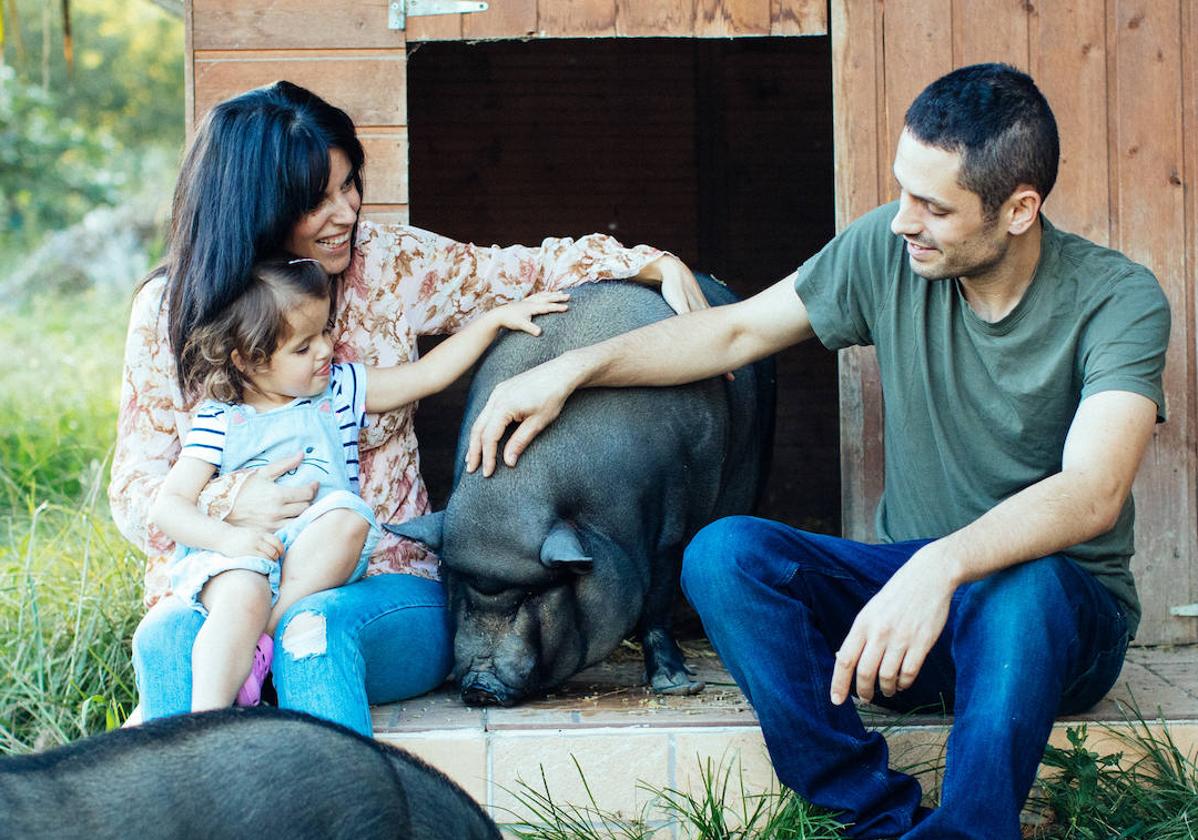 Izaskun, la exitosa 'influencer' vegana que vive con su familia y una cerdita en un caserío de Urduliz. En la imagen, posa junto a su marido, Mikel, y su hija, Maia.