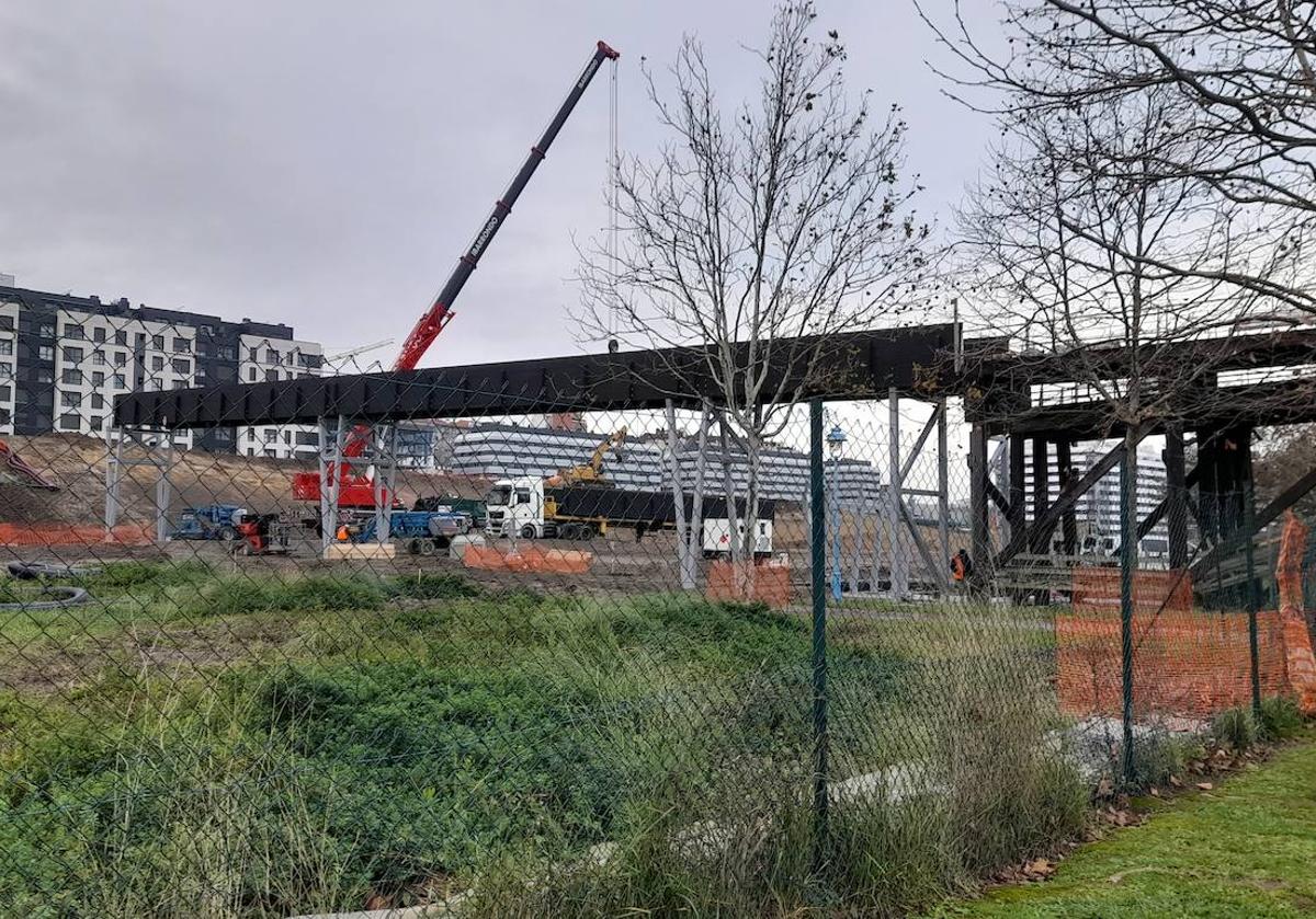 Imagen principal - Una grúa ha colocado la pasarela, que enlaza con la estructura del cargadero. Sobre estas líneas, parte del paseo cortado de manera provisional por las obras. 