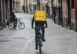 Un repartidor de Glovo ajeno a los hechos pedalea por una calle de Vitoria.