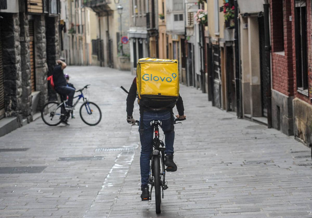 Un repartidor de Glovo ajeno a los hechos pedalea por una calle de Vitoria.