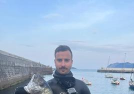 El buceador sale con una de las piezas de pescado del agua en uno de los entrenamientos.