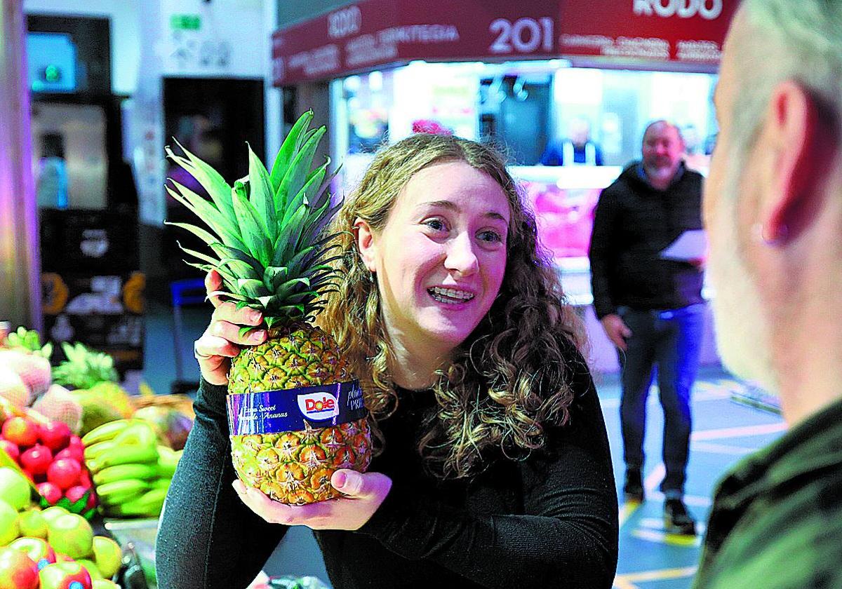 Andrea Campa Acha sostiene una piña en el Mercado de la Ribera, donde asesora a los clientes.