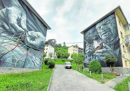 Los murales enfrentados de las manos de las 'Rederas' y del arrantzale Gabriel Arrizabalaga, en el barrio de Kamiñazpi.