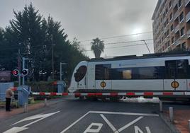 Un vecino zornotzarra espera que el tren realice su recorrido en uno de los pasos a nivel.