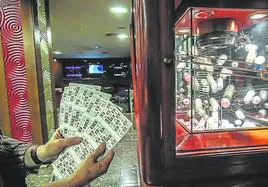 Una persona sostiene cartones de bingo en un salón de juegos.