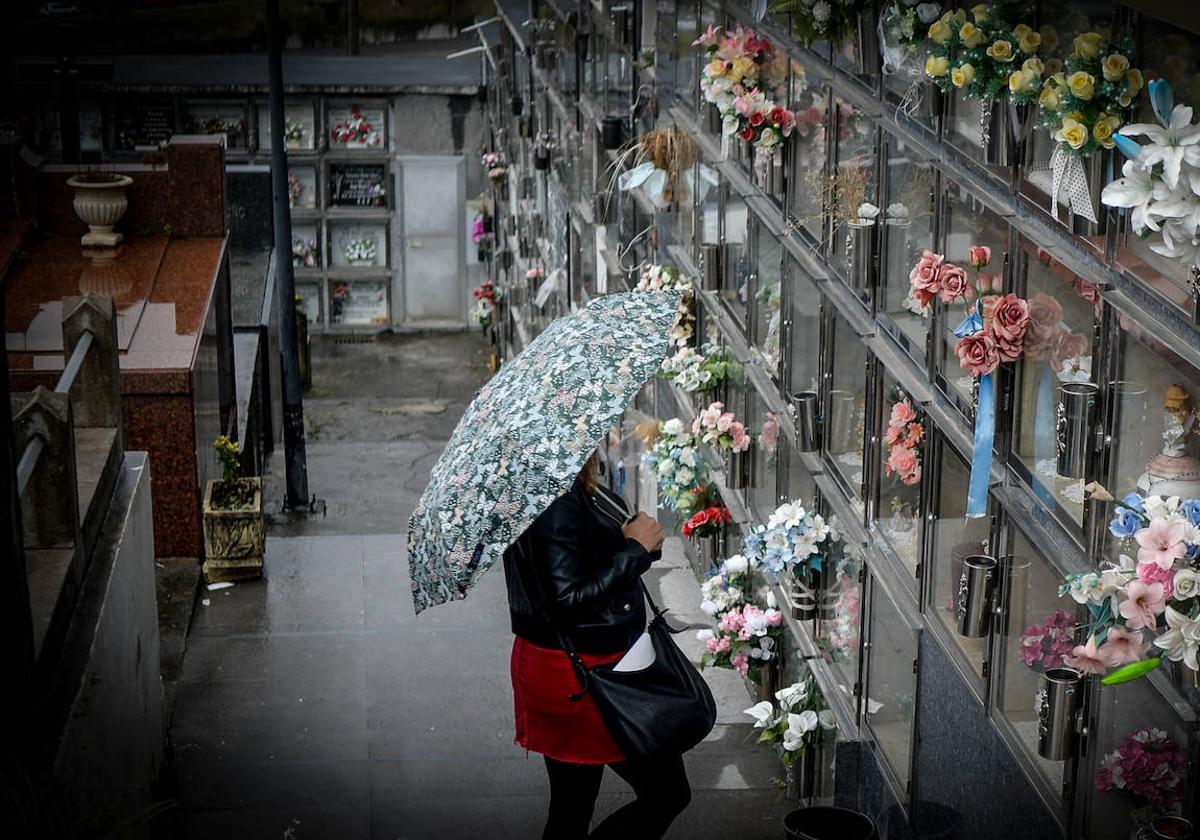 Una mujer contempla los nichos en los que están enterradas la mayoría de las víctimas en el cementerio de Ortuella.