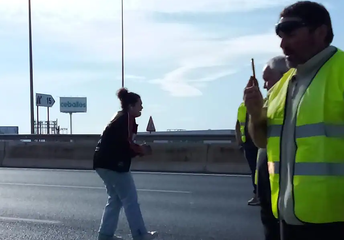 La estudiante pidiendo a los agricultores que la dejen pasar.