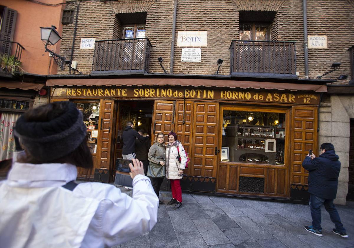 Turistas se fotografían en la entrada del Botín.