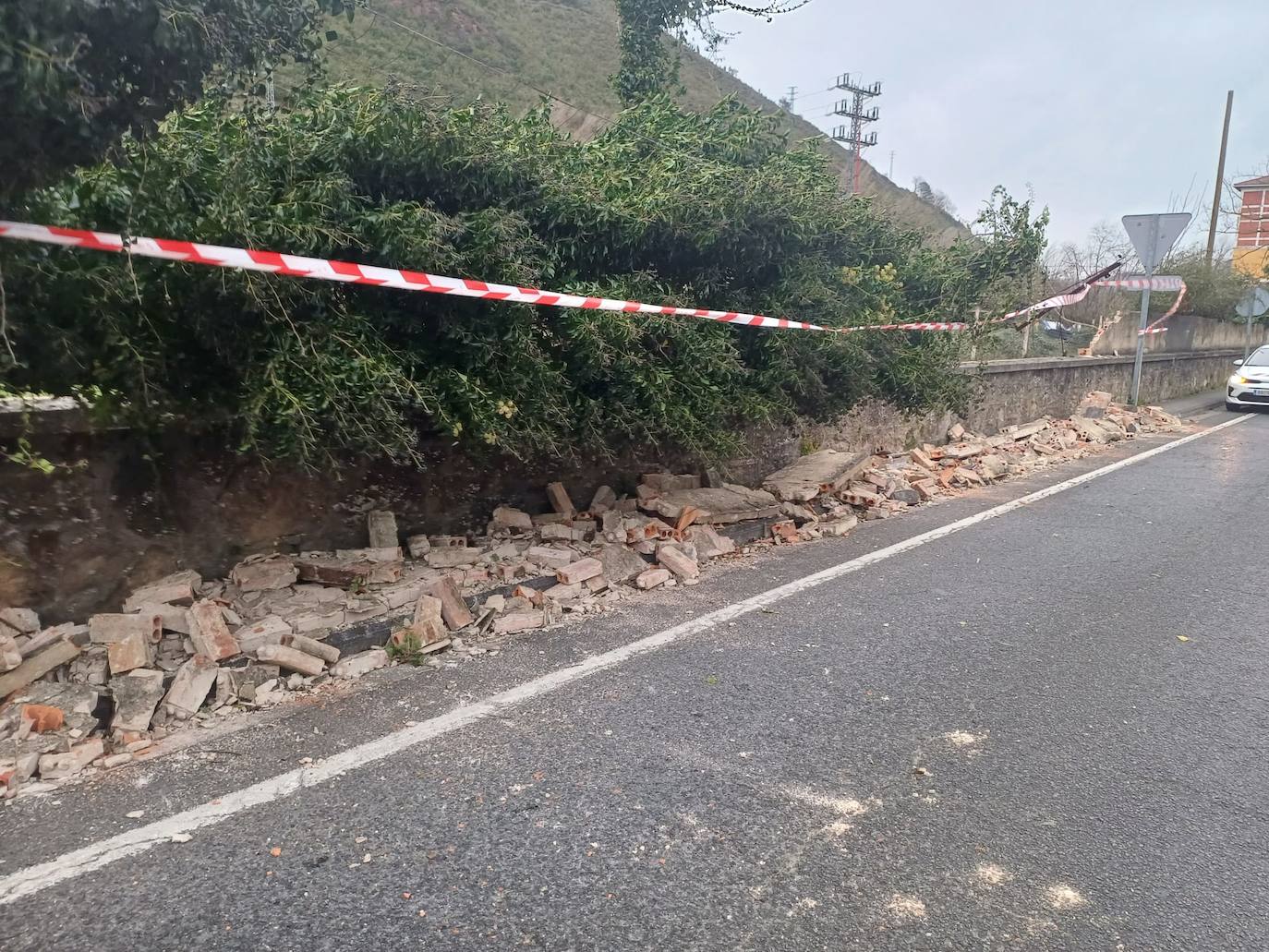 El viento ha derribado un muro junto a la carretera en Alonsotegi.