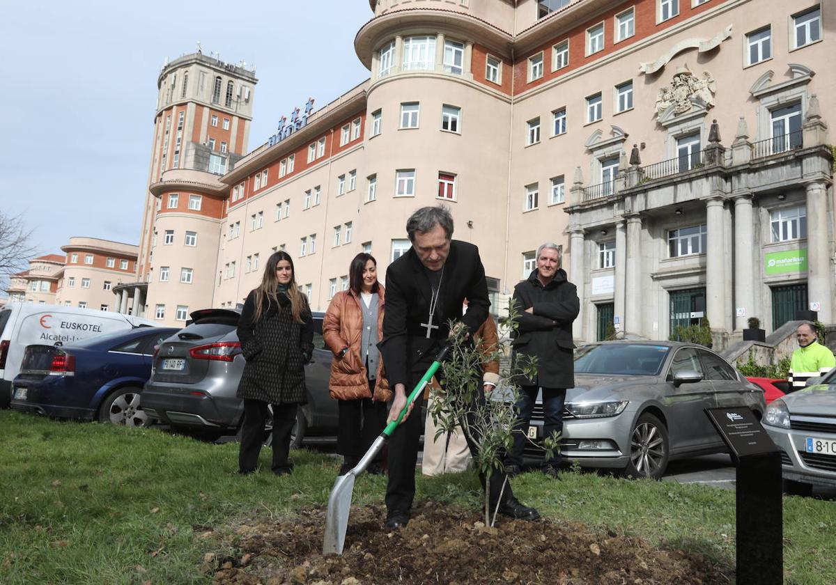 El obispo, acompañado de los miembros de la comisión, durante la plantación del olivo.