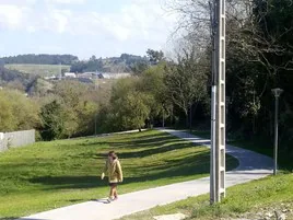 Una mujer camina por los renovados caminos de Aiboa.