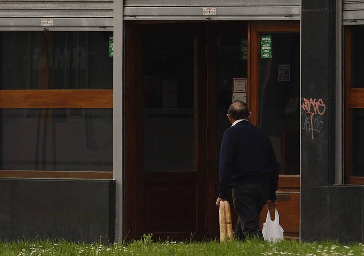 Un hombre ajeno a la noticia pasa junto a la entrada del narcobar demandado.